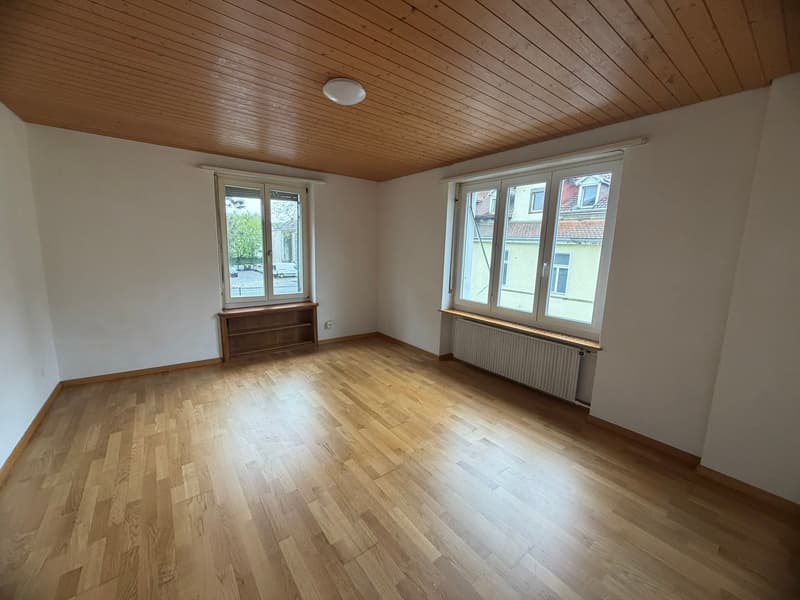 empty room, wooden floor, white walls, two windows, wooden shelf, radiator