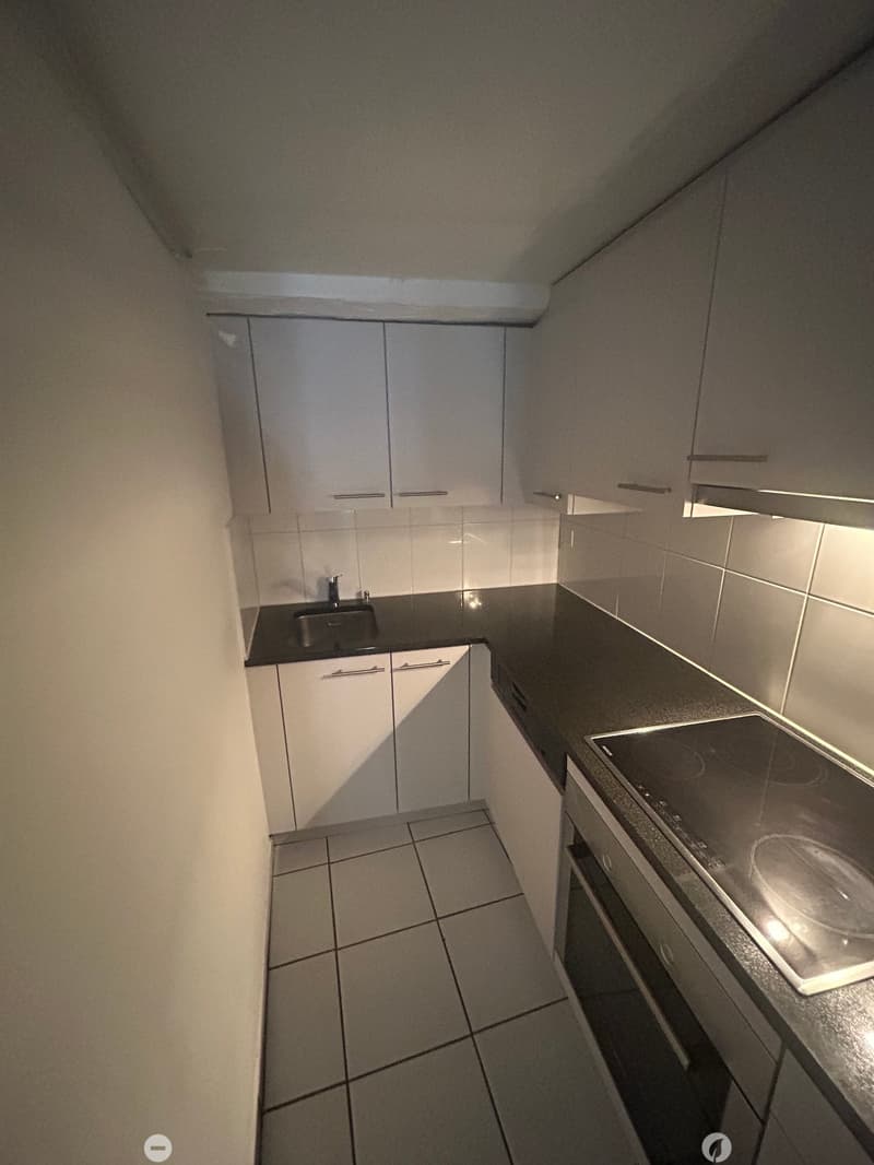kitchen with white cabinets, black countertop, silver sink, induction stove, built-in oven, and tiled floor
