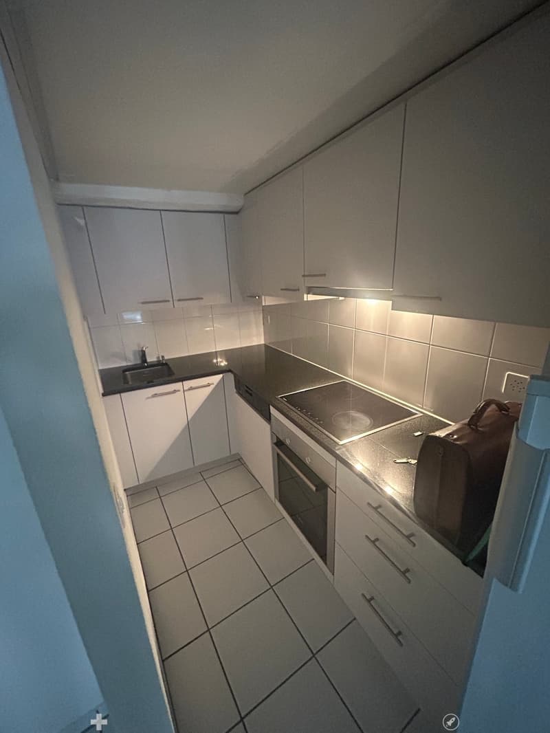 modern kitchen with integrated appliances, tiled floor, and cabinets