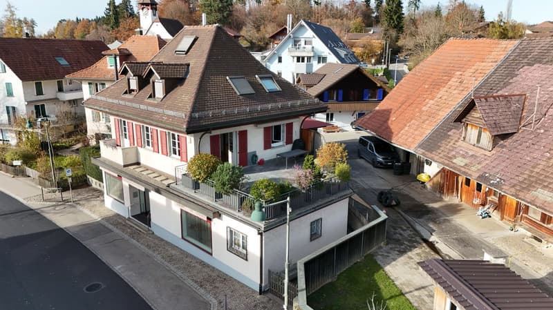 3 story house, brown roof, white and red shutters, raised ground floor, plants on roof terrace, car parked outside