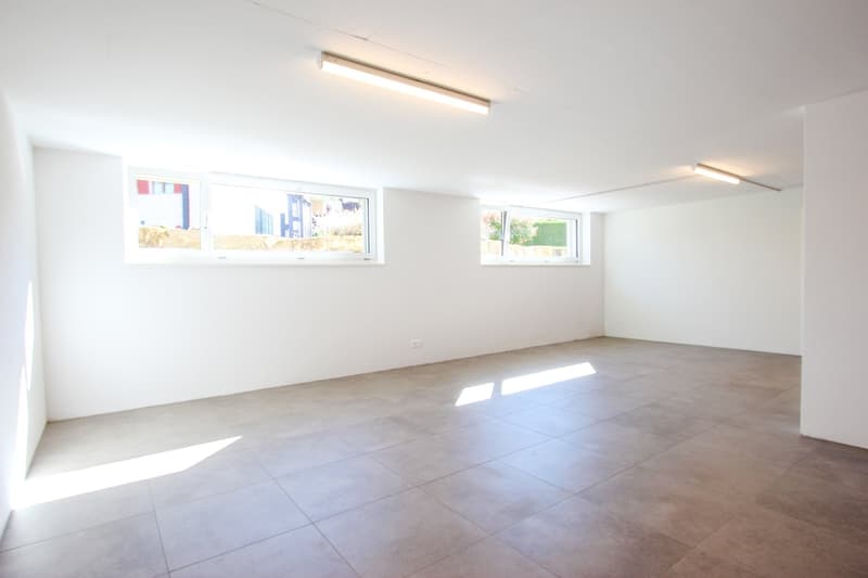 Empty room with white walls, tiled floor, and three windows on different walls