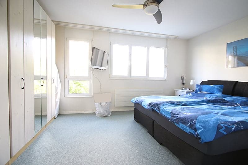 bedroom with bed, television, wardrobe, radiator, bedside lamp, nightstand