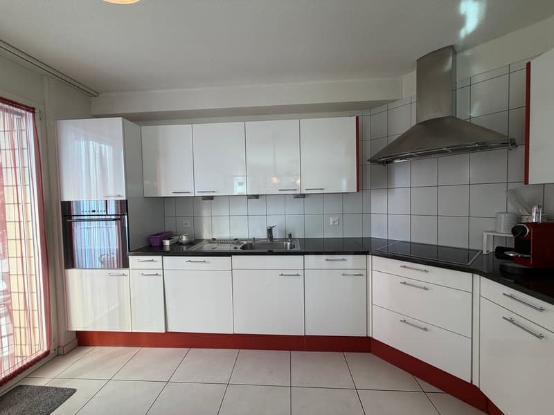 white cabinets, black countertops, stainless steel sink, silver stove, dishwasher, range hood