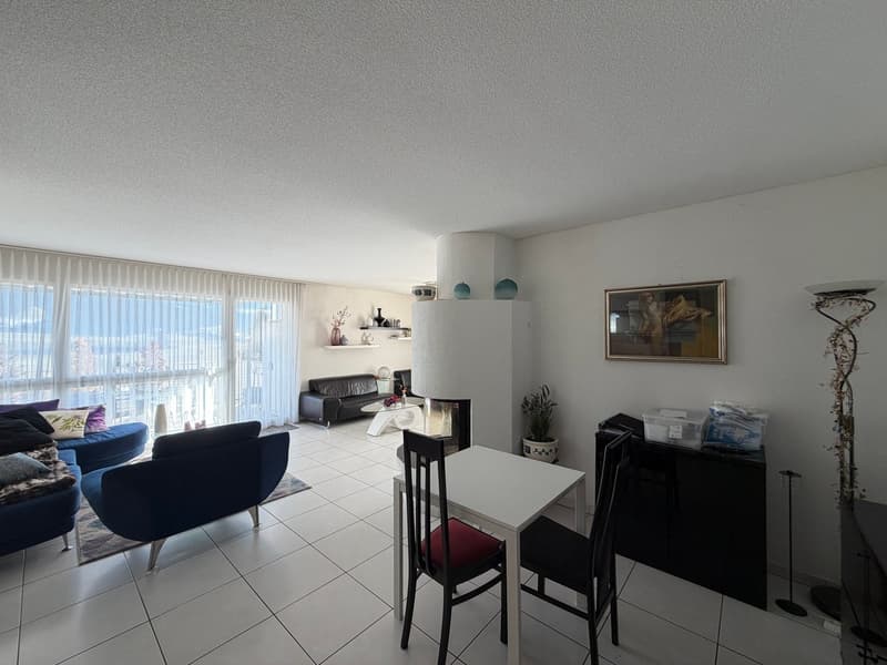 modern apartment with white tiles, glass window, dining table, blue couches, fireplace, decorative painting, shelves, white curtains