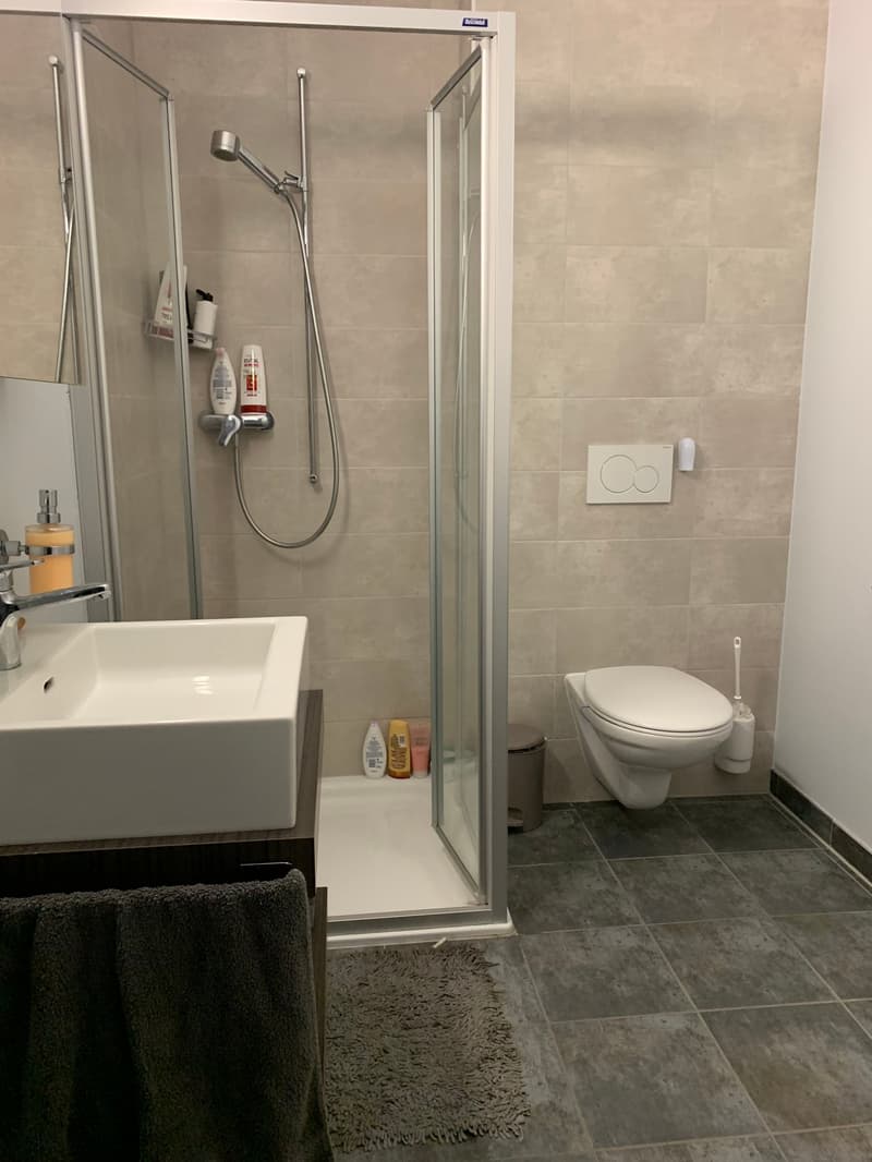 modern bathroom with shower, sink, toilet, and tiled floor