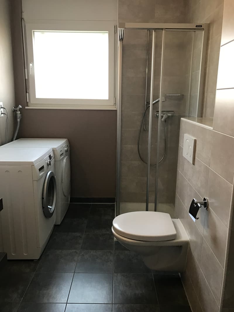 Laundry room with washing machine, dryer, and shower