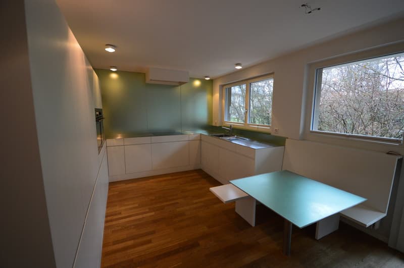 modern kitchen with wooden floor, white cabinets, stainless steel sink, large window