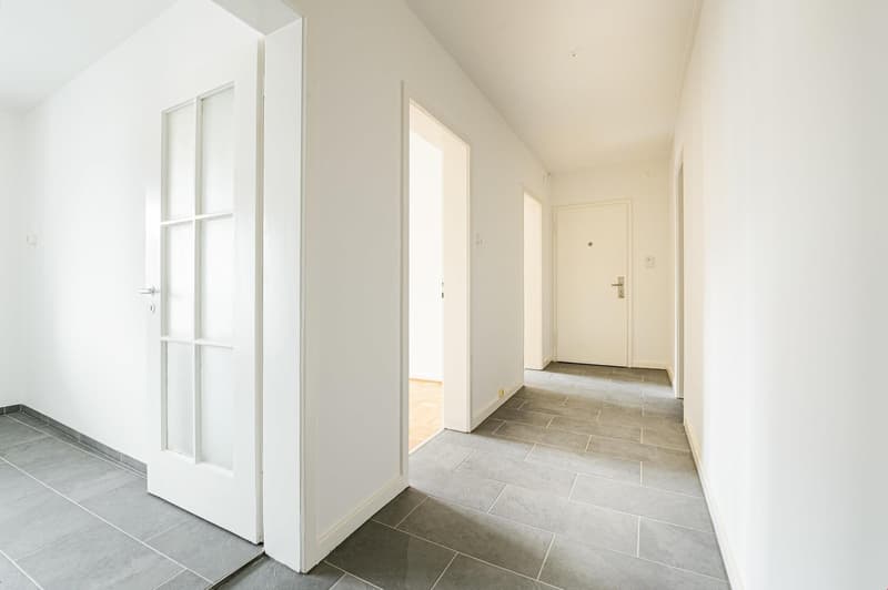 white walls, tiled floor, three doors