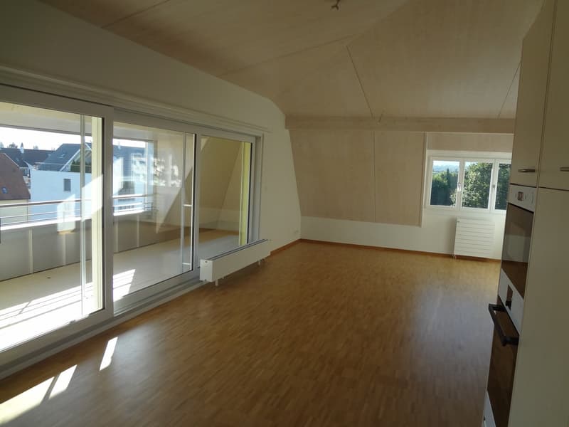 Empty room with sliding glass doors leading to a balcony, wooden flooring, and radiators.