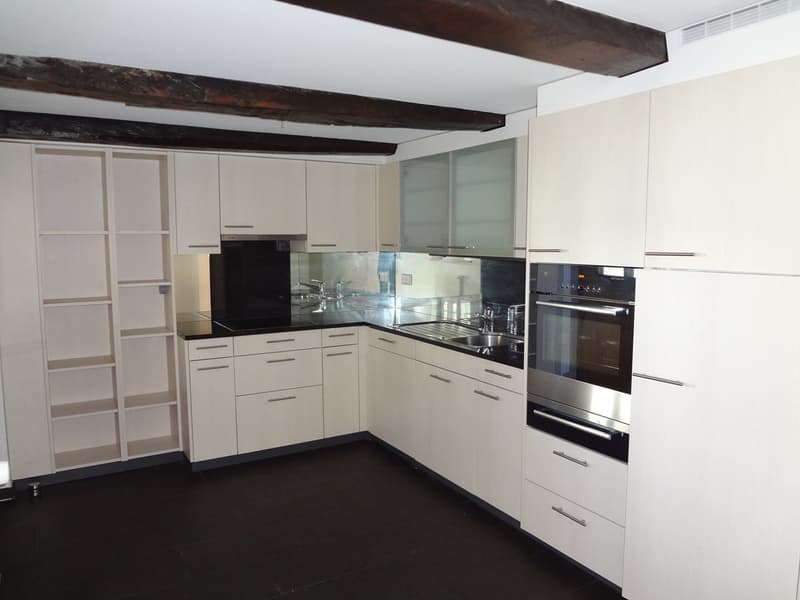 white cabinetry, black countertops, stainless steel appliances, double oven and microwave, sink with stainless steel faucet, dishwasher, and washing machine