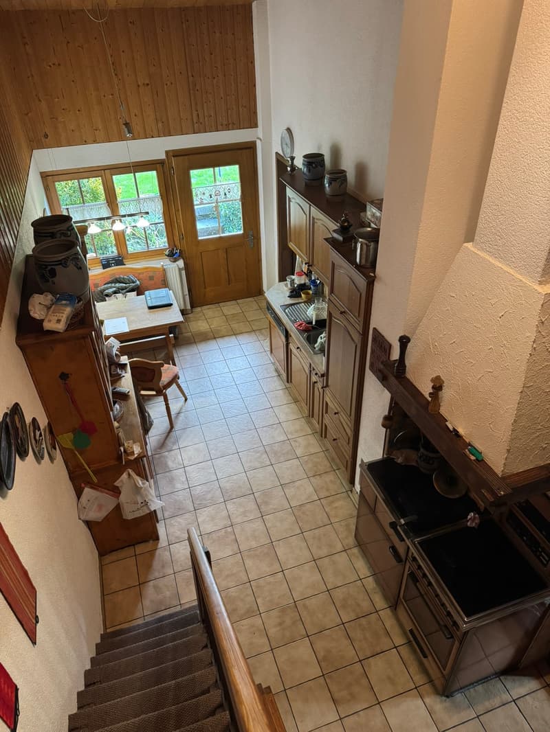 kitchen with dining area, wooden cabinets, tiled floor, fireplace, dining table, chairs, radiator, windows