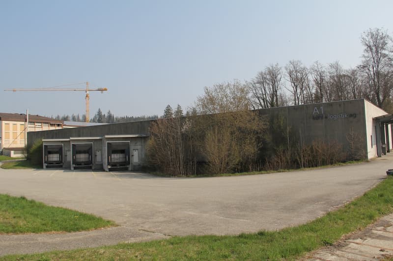 Warehouse building with three loading doors, signage on the wall