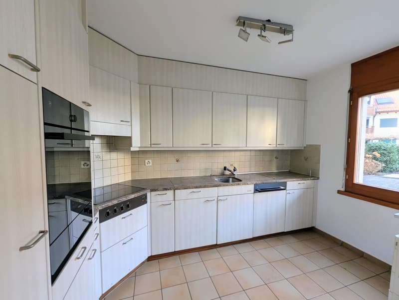 modern kitchen with white cabinets, granite countertops, built-in oven, dishwasher, sink, and tiled floor