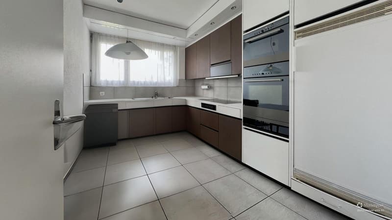 modern kitchen with white tiles, wooden cabinets, stainless steel appliances, double oven, dishwasher, sink, faucet, window with curtains