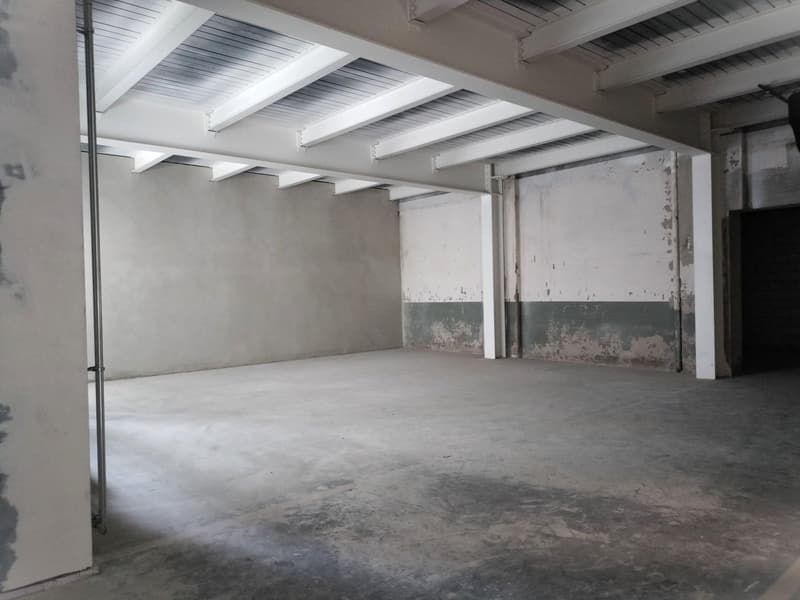 Empty space, white walls, white metal beams, concrete floor, no furniture or equipment