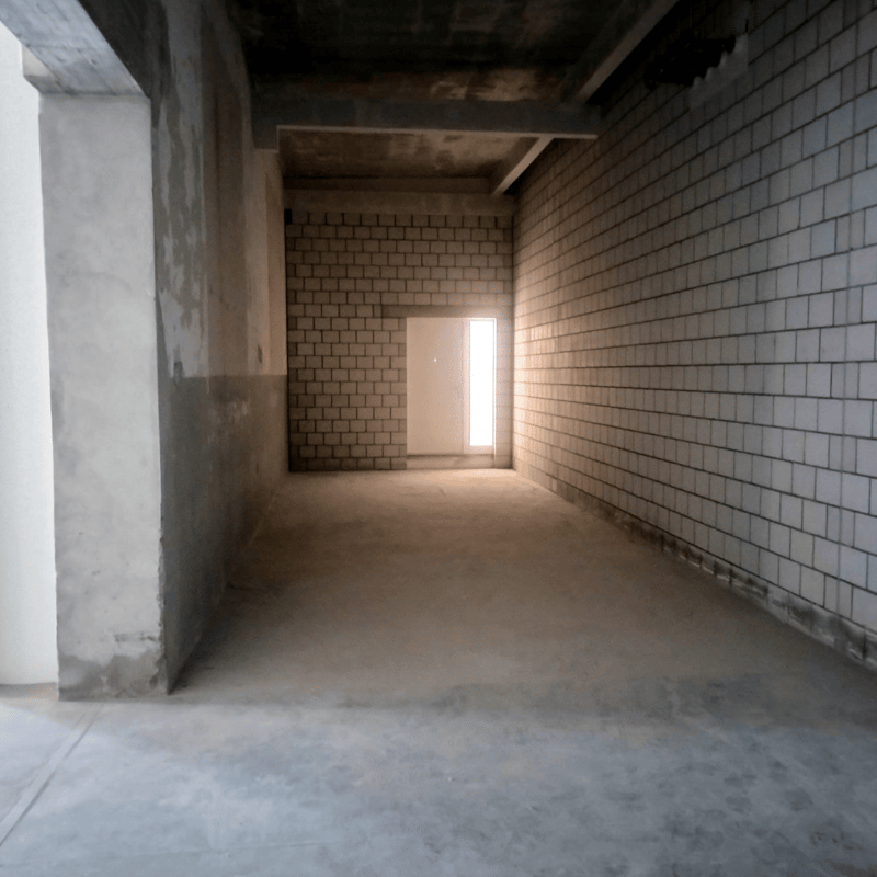 Empty room with brick walls, concrete pillars, cement floor, window and door at the end