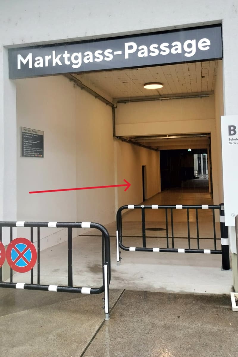 Main entrance of the Marktgasse-Passage, two metal gates, no people visible, signage indicating the location
