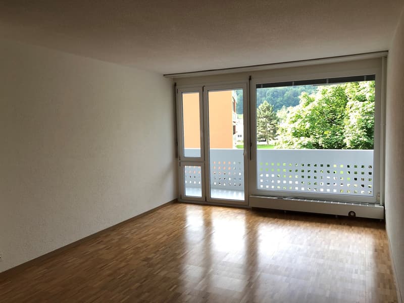 empty room, wooden floor, white walls, sliding glass doors, balcony, view of trees