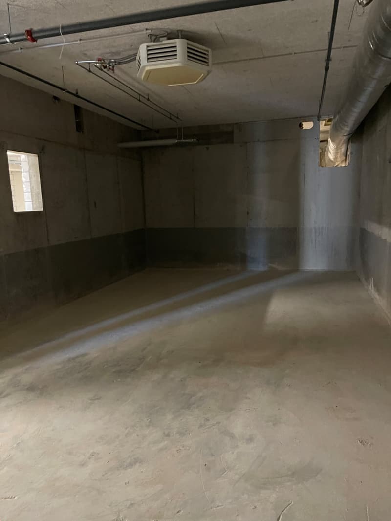 Empty room, cement walls, cement floor, metal pipes, windows, ventilation