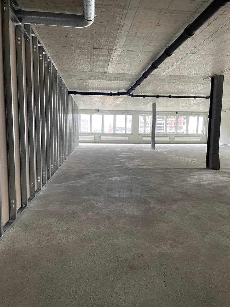 empty room, concrete floor, metal beams, large windows