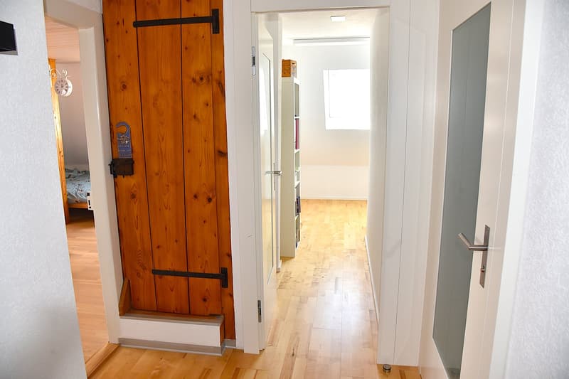 wooden doors, white walls, wooden floors, natural light from a window, closet