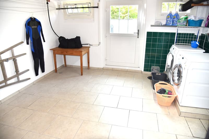 wooden table, clothes rack, green shelves, washing machine, baskets