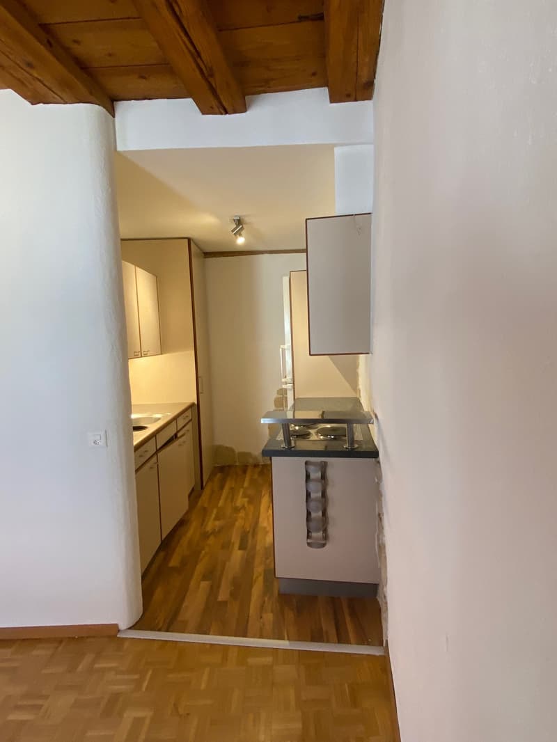 kitchenette with sink, oven, cabinets, and a wall-mounted power outlet