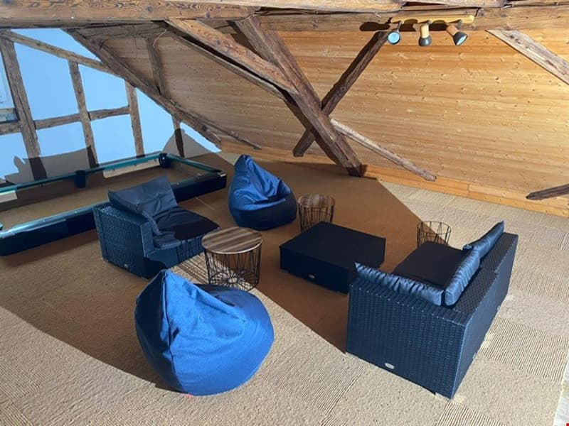Wooden beams and ceiling, bean bag chairs, wicker furniture, cozy seating area