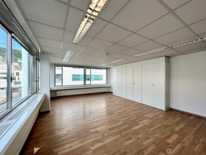 Empty room, large windows, white walls, white ceiling, wooden floor, built-in white cabinets