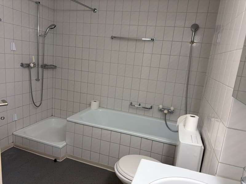 Bathroom with bathtub, shower, toilet, sink, and white tiled walls