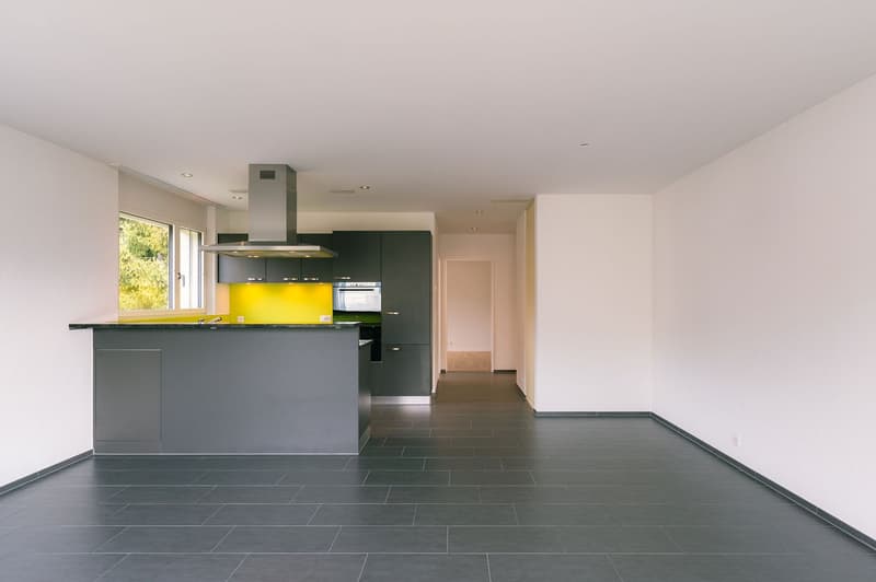 modern kitchen with gray cabinets, yellow wall, black tiled floor, stainless steel range hood, built-in oven, large window