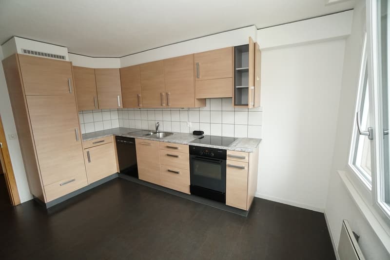 modern kitchen with wooden cabinets, granite countertops, black appliances, sink, faucet, window