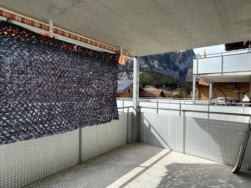 Balcony with metal railings, black shade cover, and a view of the mountains
