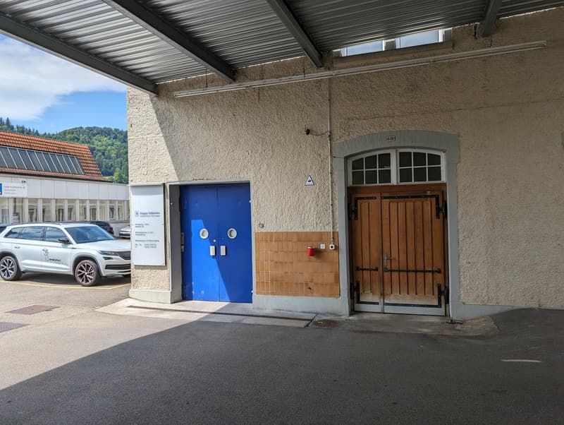 Building exterior with parking area, double doors, solar panels on adjacent building
