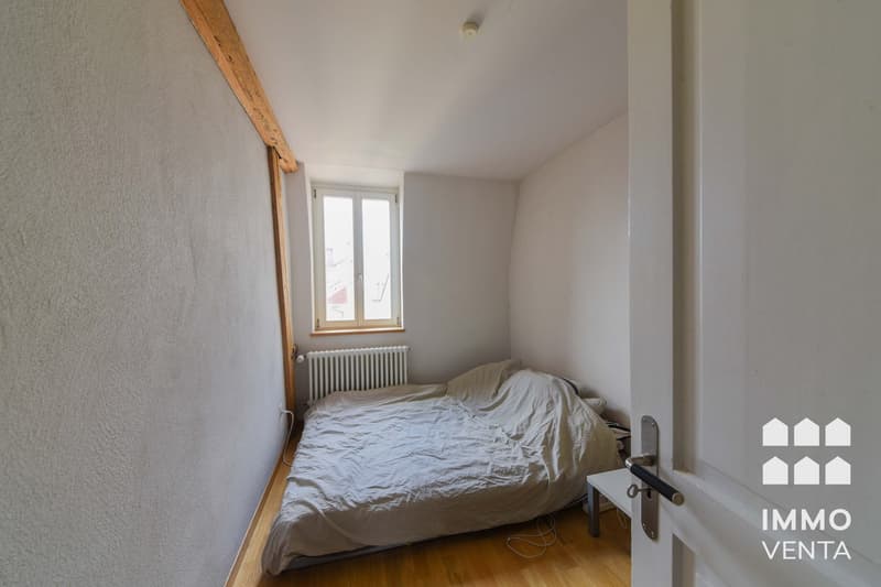 small bedroom with bed, window, radiator, wooden floor