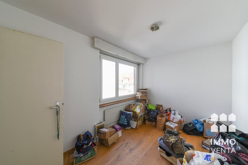 empty room, wooden floor, white walls, window, boxes and bags on the floor