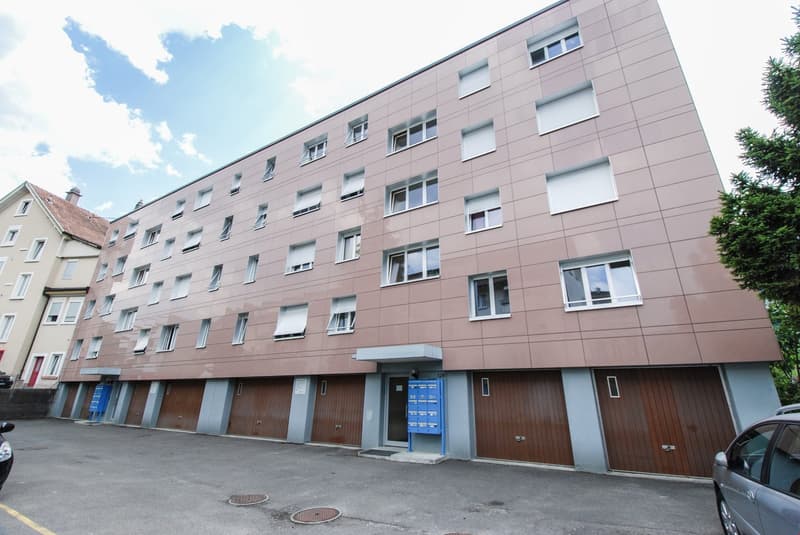 4 story building, brown exterior, multiple windows, multiple garages