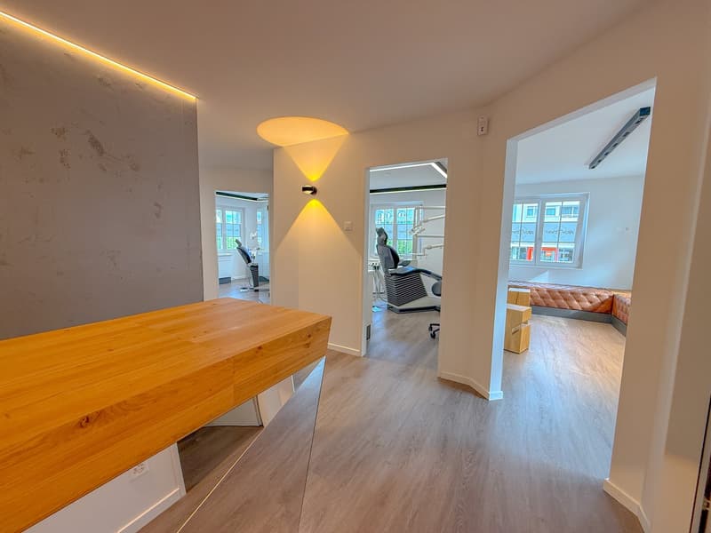 wooden desk, hardwood floor, white walls, 2 chairs, window with view