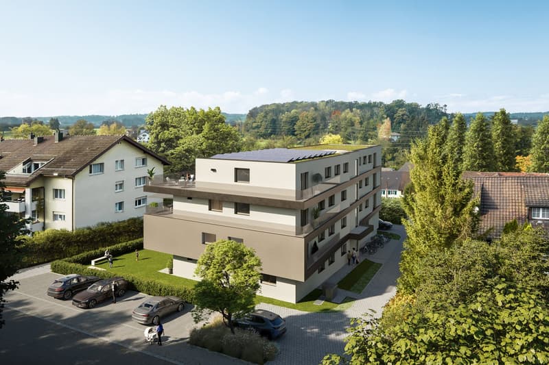 Multi-story apartment building with a flat roof, surrounded by trees and greenery. There is a parking area in front of the building.