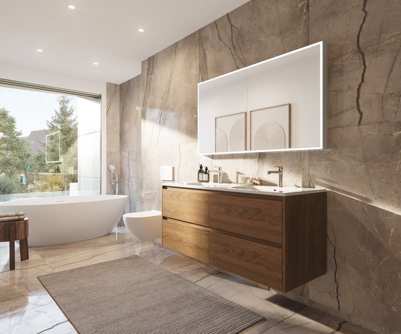 Spacious bathroom with large marble-like wall tiles, a freestanding bathtub, a wooden vanity with drawers, and a backlit mirror above the vanity. The bathroom also features a rug on the floor.