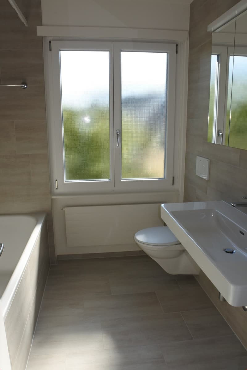 Bathroom with bathtub, toilet, sink, and window