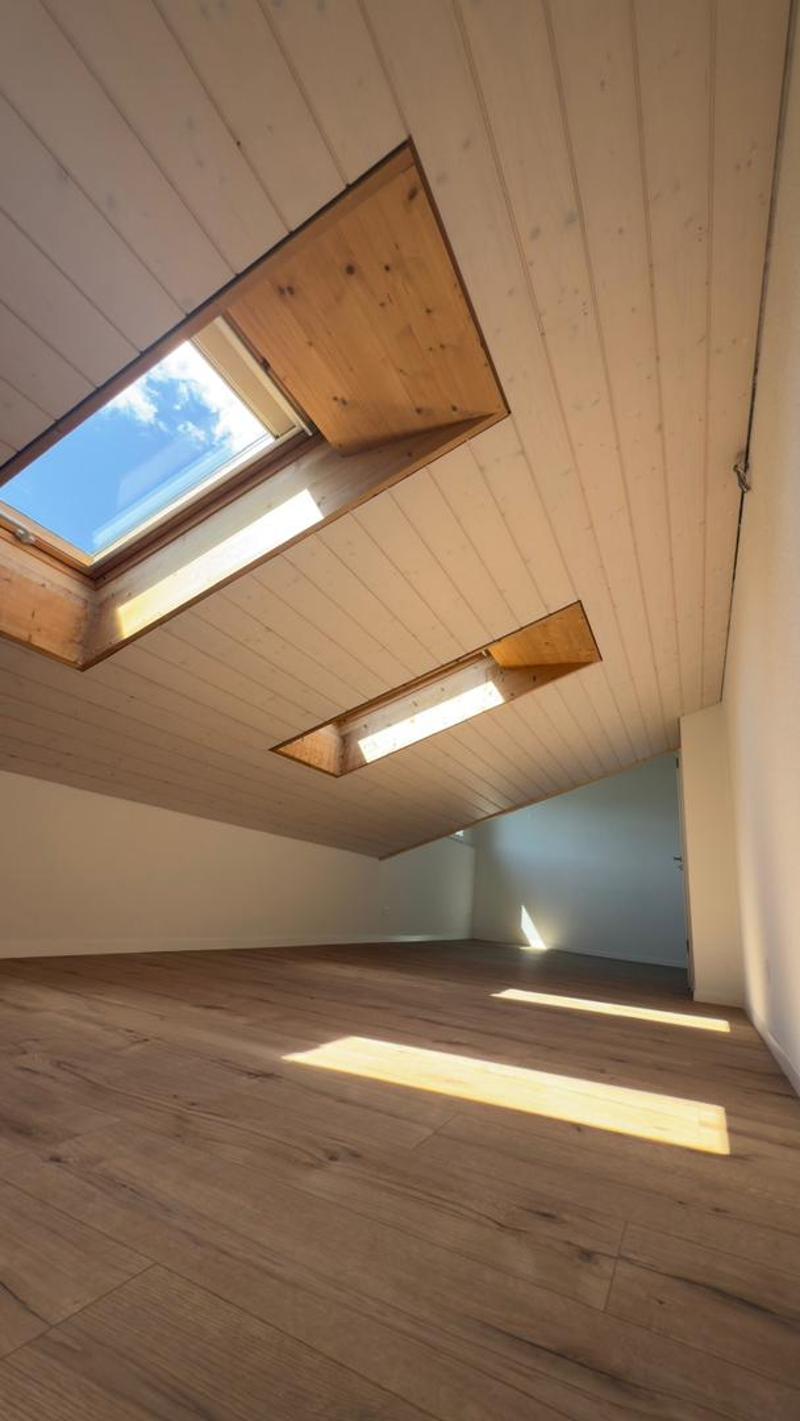empty room, wooden floor, white walls, two skylights, wooden ceiling