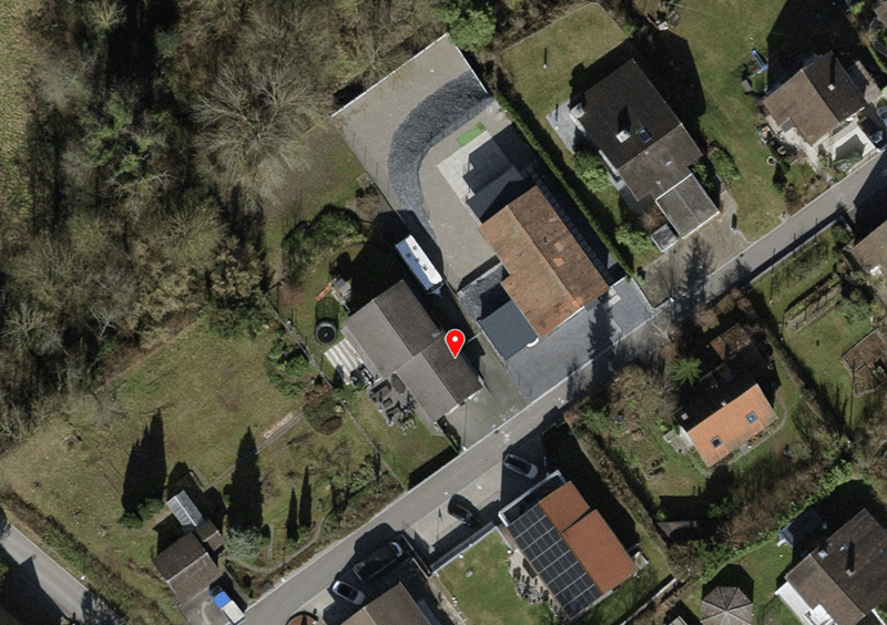 House with garage, driveway, multiple houses in the area, solar panels on one house