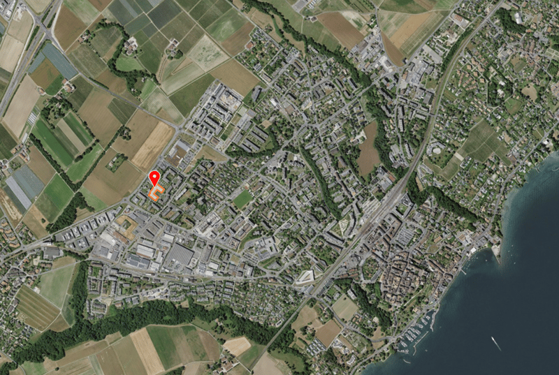 Aerial view of a town with buildings, roads, and a body of water.
