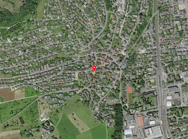Aerial view of a town with many buildings, roads, and green spaces