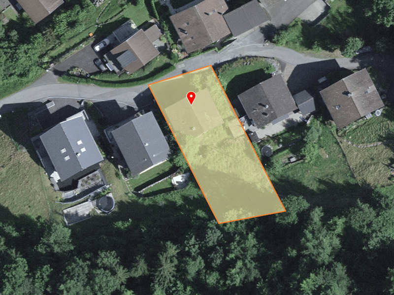 Plot of land with a rectangular shape, surrounded by houses and greenery.
