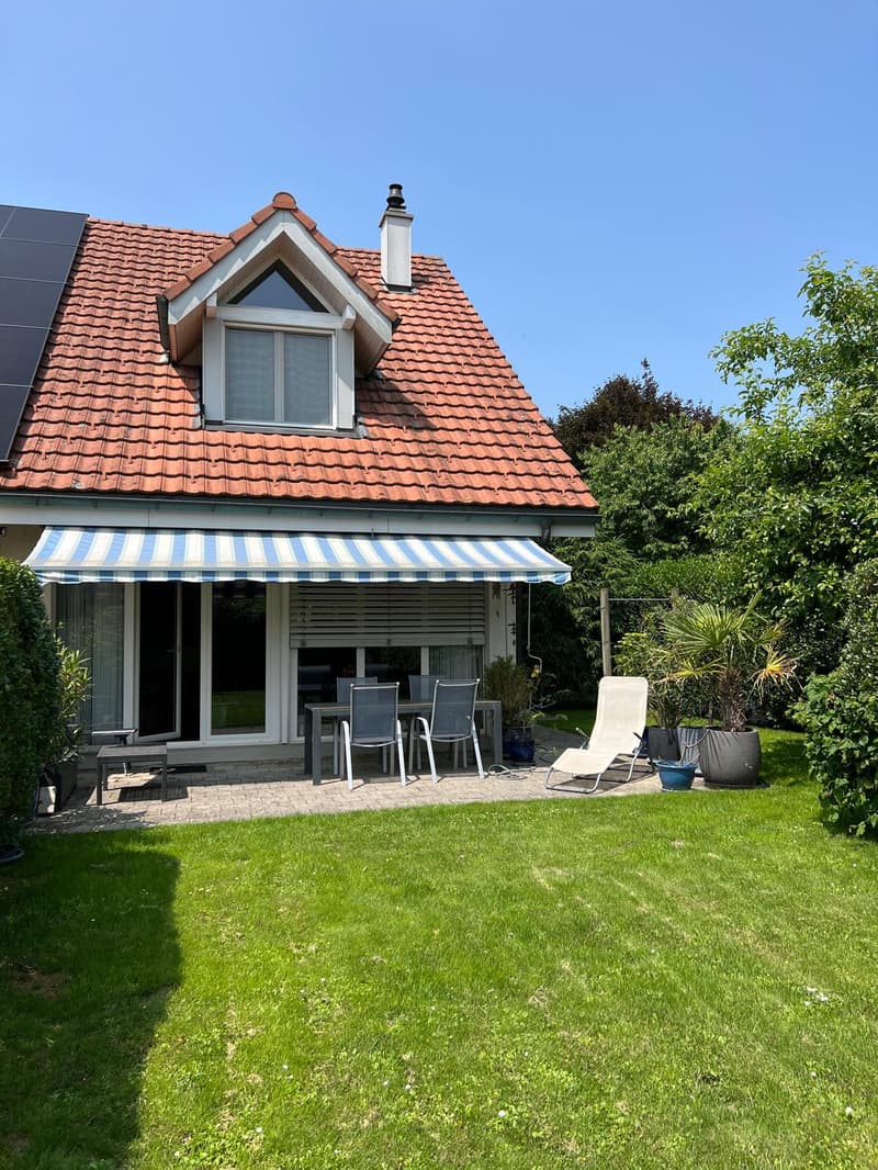 Detached house, red roof, solar panels, awning, outdoor dining area, lounge chair, garden, plants