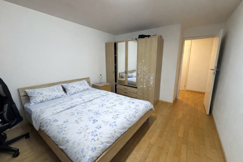 double bed, wooden floor, large wardrobe, mirror, desk, chair, bottle