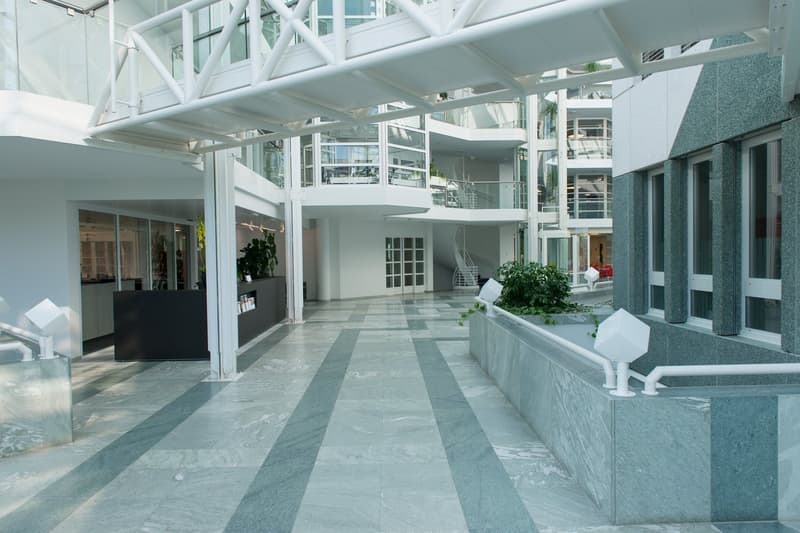 modern building, white walls, glass windows, marble flooring, white railings, plants