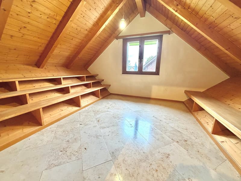 empty attic room with wooden ceiling, wooden shelves, white tiles, window